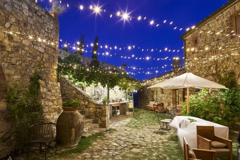 the extraordinaire tuscany castello di vicarello inner stone courtyard with fairy lights