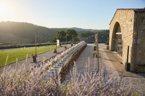 the extraordinaire tuscany podere tesoro imperial table setup in front of event hall at sunset
