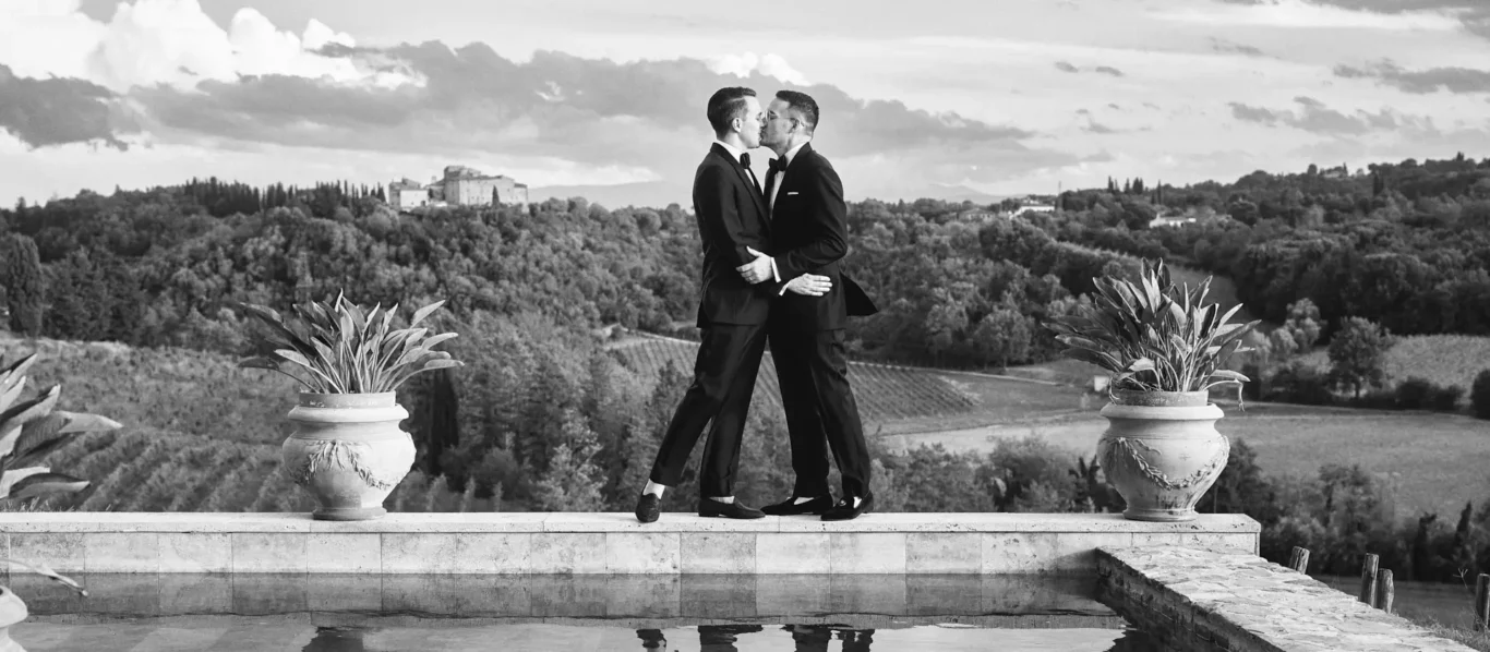 the extraordinaire lgtbq plus wedding planner in italy black and white photo couple kissing poolside in tuscany